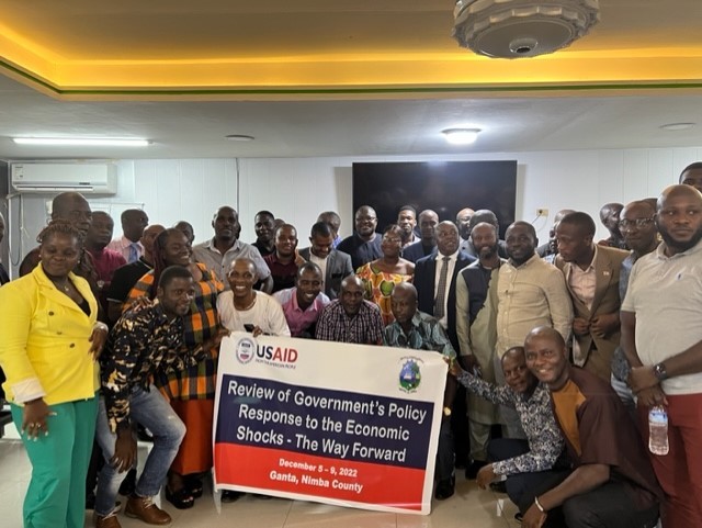 Group of people standing together and holding USAID program banner