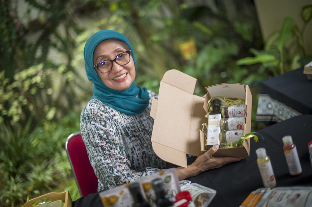 Jullie Hakim holding a gift box of her products