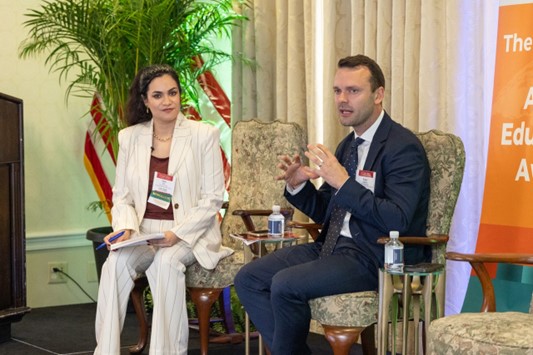 Man and woman seated in chairs having a discussion